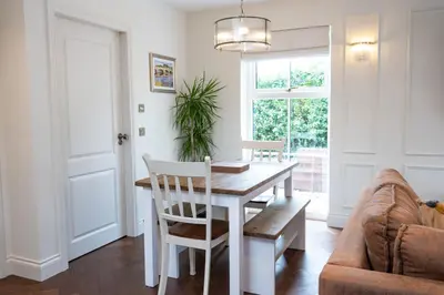 a dining room with a table and a couch at Our Cosy Cottage in Gatehouse of Fleet