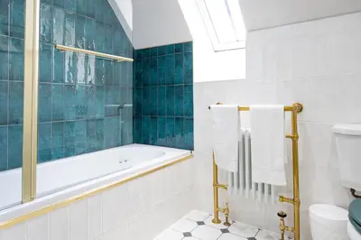 a bathroom with a tub and a toilet and a sink at Our Cosy Cottage in Gatehouse of Fleet