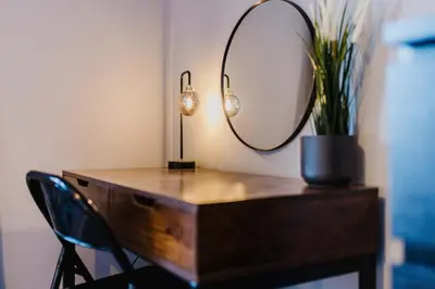 a desk with a mirror and a potted plant at Welcoming Home in Hurlford, Kilmarnock - Bonnie Lodgings in Hurlford