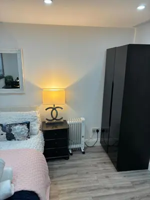 a bedroom with a bed and a dresser with a lamp at Hertford detached home garden pet friendly parking in Moffat