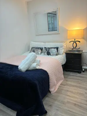 a bedroom with a bed and a mirror on the wall at Hertford detached home garden pet friendly parking in Moffat