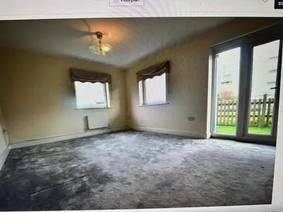 an empty room with windows and a large room with concrete floors at Grebe House in Moffat