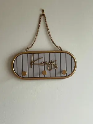 a mirror hanging on a wall with a pair of scissors at Williamsfield Cottage in Holywood