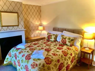 a bedroom with a bed with a floral bedspread at The MireHouse - Georgian rural retreat in Ullock