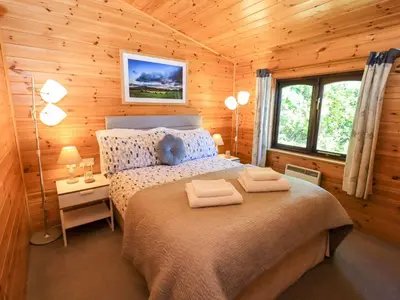 a bedroom with a bed in a wooden cabin at Watendlath in Keswick