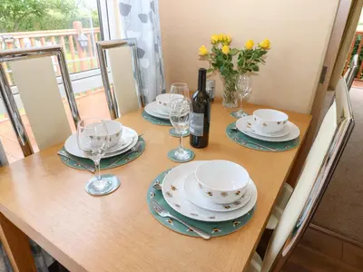 a table with plates and glasses and a bottle of wine at 12 Field View in Carlisle