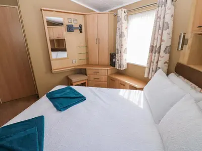 a bedroom with a large bed and a window at 12 Field View in Carlisle