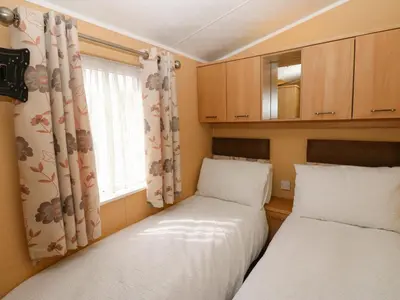two beds in a small room with a window at 12 Field View in Carlisle
