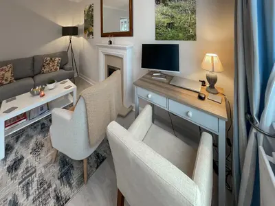 a living room with two chairs and a desk with a computer at Rubby Banks Retreat in Cockermouth