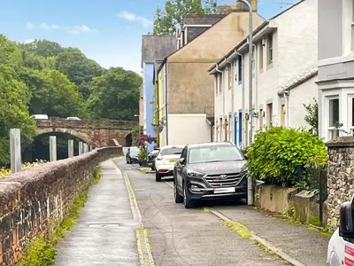 a row of cars parked on a street next to buildings at Rubby Banks Retreat in Cockermouth