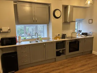 a kitchen with a sink and a clock on the wall at Swirral Edge Cottage in Penrith