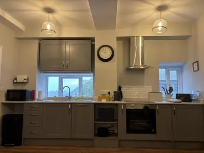a kitchen with a sink and a clock on the wall at Swirral Edge Cottage in Penrith