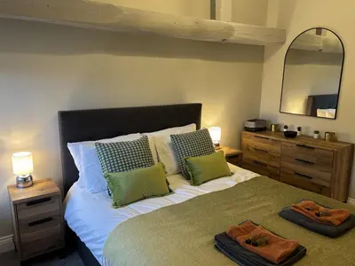 a bedroom with a bed with two towels on it at Swirral Edge Cottage in Penrith