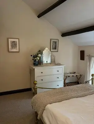 a bedroom with a bed and a dresser with a mirror at Sycamore Cottage - Lake District Hiking & Rivers in Cockermouth