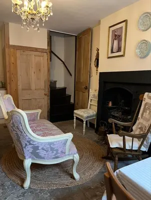 a living room with chairs and a fireplace at Sycamore Cottage - Lake District Hiking & Rivers in Cockermouth