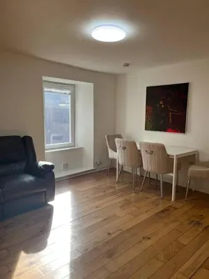 a living room with a couch and a table and chairs at Lower Mill Apartment in Newmilns
