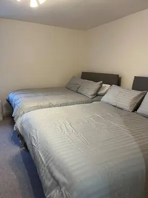 two beds sitting next to each other in a room at Lower Mill Apartment in Newmilns