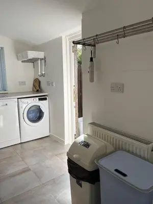 a laundry room with a washing machine and a washer at Lower Mill Apartment in Newmilns