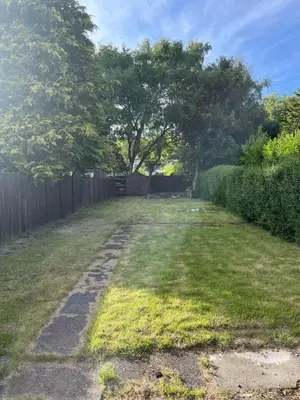 an empty yard with a fence and a tree at Lower Mill Apartment in Newmilns
