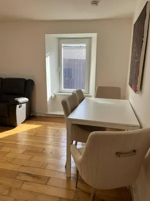 a living room with a table and a chair at Lower Mill Apartment in Newmilns