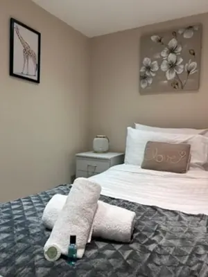 a bedroom with a bed with a towel on it at Abbeygreen Village House in Lesmahagow