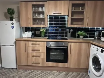a kitchen with wooden cabinets and a white refrigerator at Abbeygreen Village House in Lesmahagow