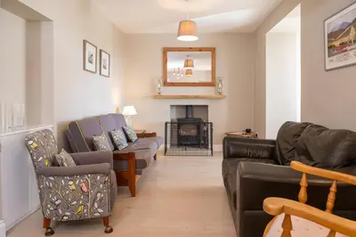 a living room with couches and a fire place at Larroch Farmhouse in Monreith
