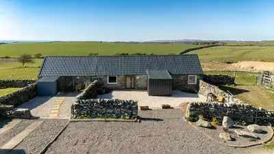 an aerial view of a house with a group of stone walls at The Larroch Byre in Monreith