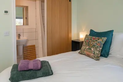 a bedroom with a bed with two towels on it at The Larroch Byre in Monreith