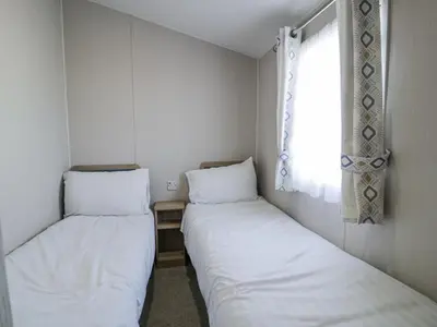 two beds in a small room with a window at Manor House Platinum 3 Bedroom 16E in Maryport