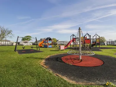 a park with a playground with a slide at Manor House Platinum 3 Bedroom 16E in Maryport