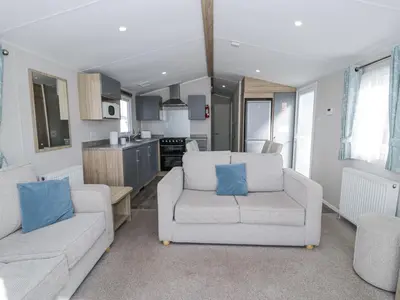 a living room with two couches and a kitchen at Manor House Platinum 3 Bedroom 16E in Maryport