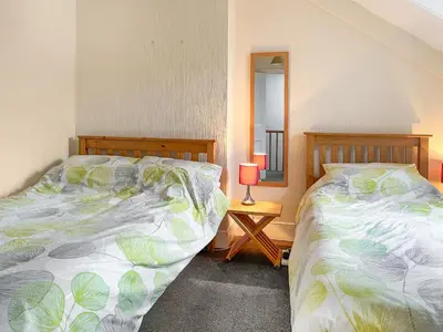 a bedroom with two beds and a mirror at The Haven in Annan