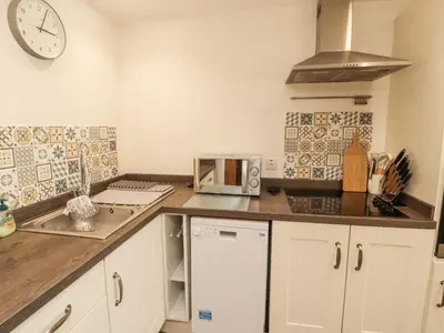 a kitchen with a counter top with a microwave at Sun House in Maryport