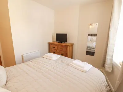 a bedroom with a bed and a tv on a dresser at Sun House in Maryport