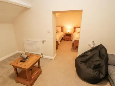 a room with a couch and a table and two beds at Sun House in Maryport