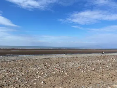 a group of people walking on a rocky beach at Sun House in Maryport