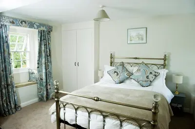 a bedroom with a bed with blue and white pillows at Charming cosy Lakeland cottage near Ullswater in Dacre