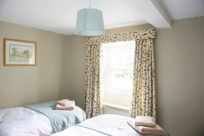 a bedroom with a window with a window curtain at Charming cosy Lakeland cottage near Ullswater in Dacre