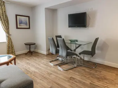 a living room with a glass table and chairs at King's Apartment in Castle Douglas