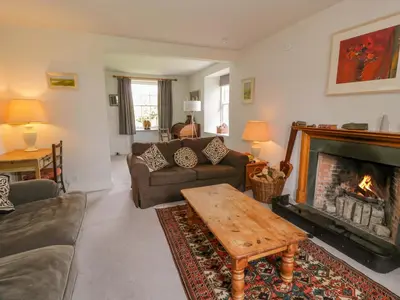 a living room with a fireplace and a couch at Townhead of Auchenbainzie in Thornhill