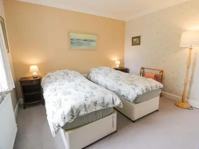 a bedroom with two twin beds and two lamps at Townhead of Auchenbainzie in Thornhill