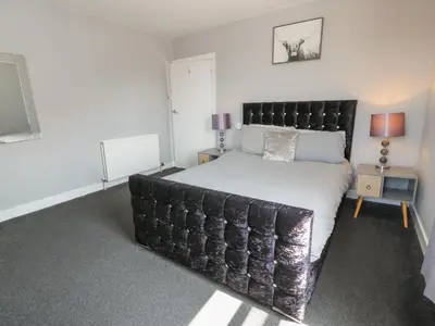 a bedroom with a large bed with a black headboard at Fleet Townhouse in Castle Douglas