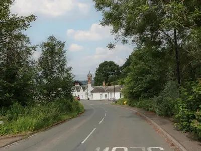 an empty road with white houses and a clock tower at Fleet Townhouse in Castle Douglas