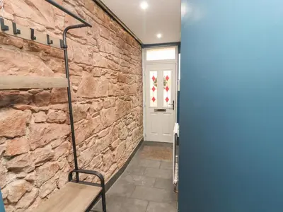 a hallway with a stone wall and a bench at 10 Keekle Terrace in Cleator Moor