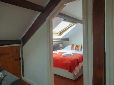 a bedroom with a bed with a red blanket at Emilys View, Ireby budget accommodation with fell views in Ireby