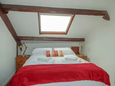 a bedroom with a bed with a red blanket at Emilys View, Ireby budget accommodation with fell views in Ireby