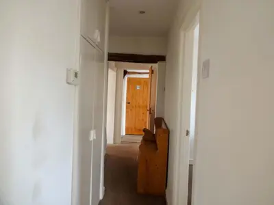 a hallway with a door and a chair in a room at Emilys Apartment, Ireby with fell views, ideal budget holiday for a family in Ireby