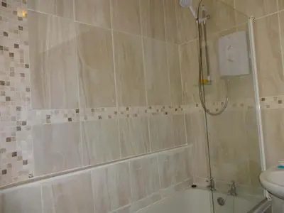 a bathroom with a shower and a tub and a sink at Emilys Apartment, Ireby with fell views, ideal budget holiday for a family in Ireby