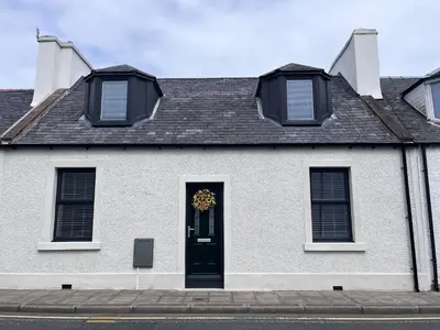 a white house with a wreath on the door at Beach House in Stranraer